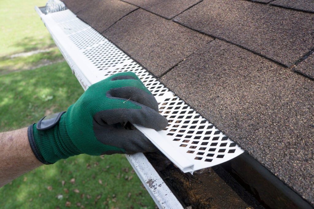 how to install gutter guards Contractor adjusting plastic gutter guards to get them to fit.