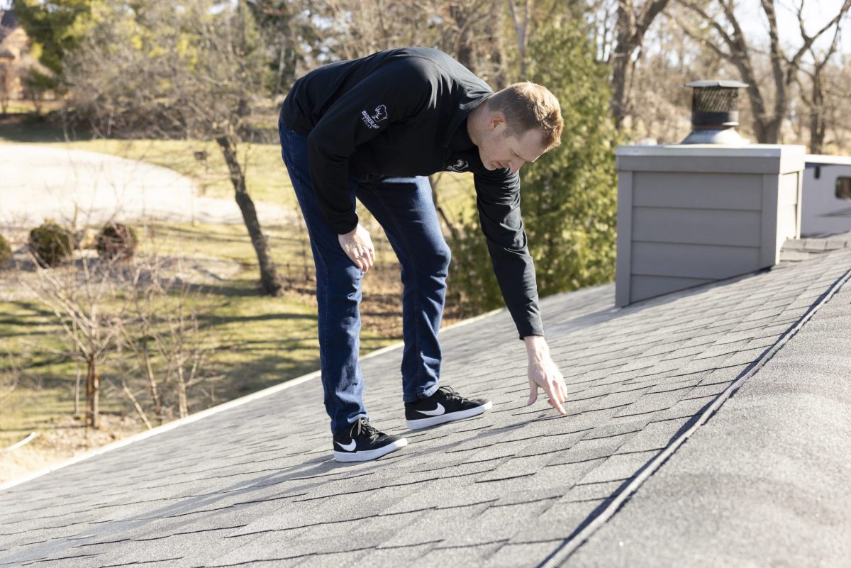 roof inspection wisconsin guy inspecting grey shingles roof